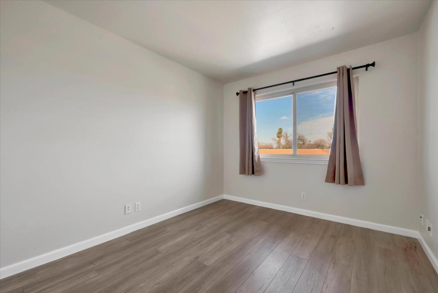 231 Watson Drive, Unit 4 Campbell, CA 95008 - Photo 12 of 16 an empty room with wooden floor and mirror