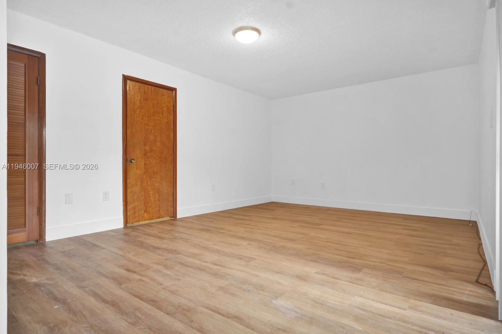 326 East 34th Street Hialeah, FL 33013 - Photo 17 of 26 a view of an empty room with wooden floor and a window