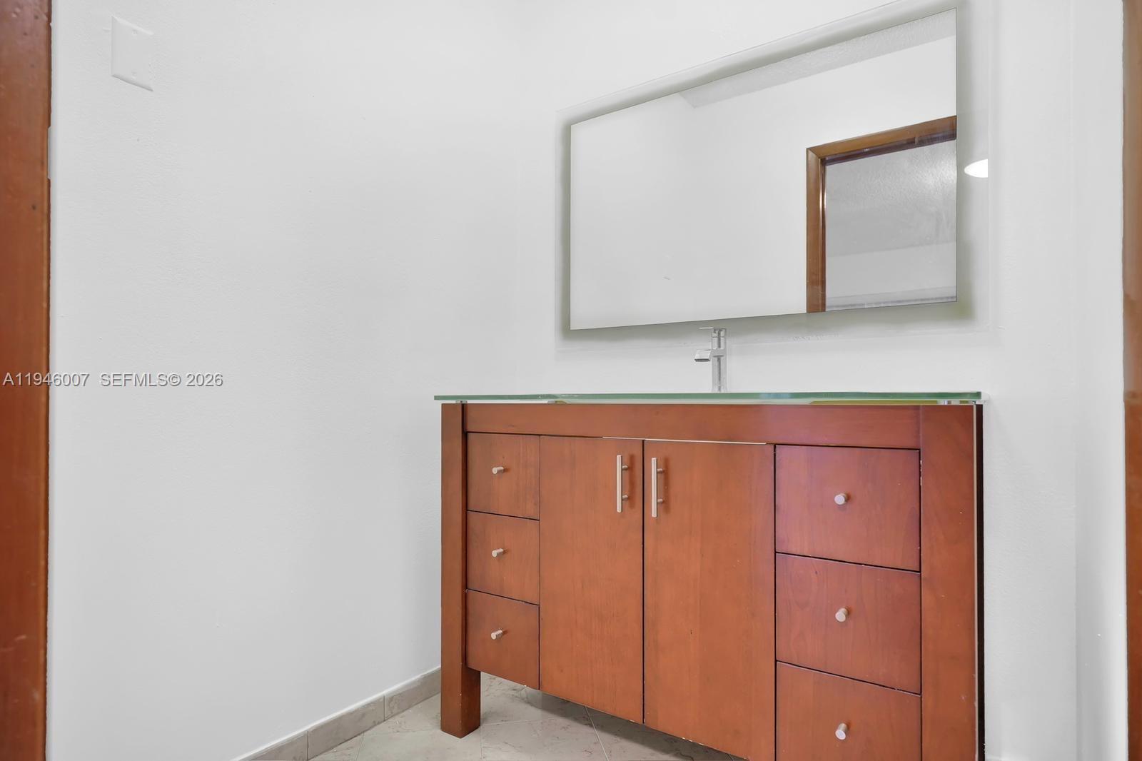 326 East 34th Street Hialeah, FL 33013 - Photo 18 of 26 a bathroom with a mirror and a sink