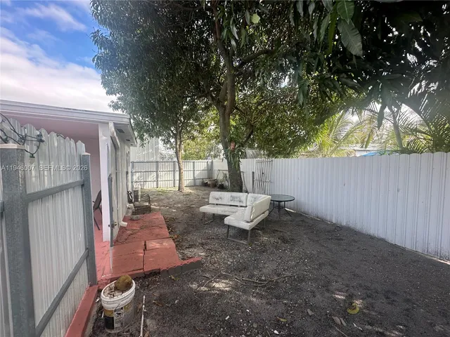 a view of backyard with outdoor seating and trees