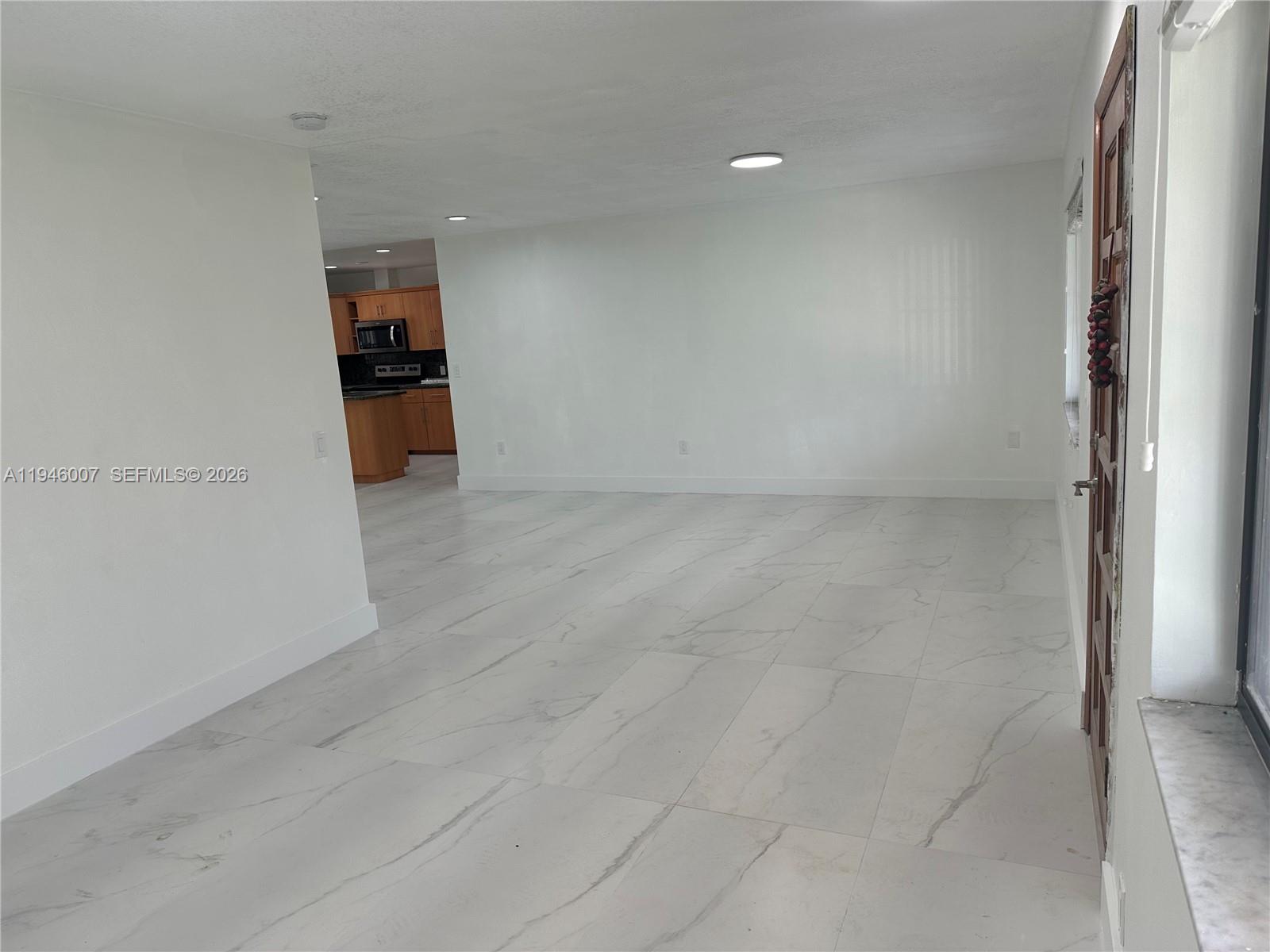 326 East 34th Street Hialeah, FL 33013 - Photo 7 of 26 an empty room with kitchen view and a window