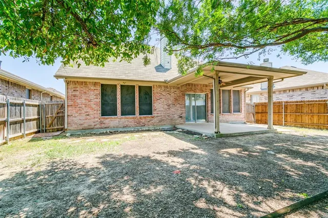 a view of a house with a backyard and a large tree
