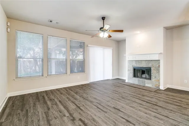 a view of an empty room with glass door and wooden floor
