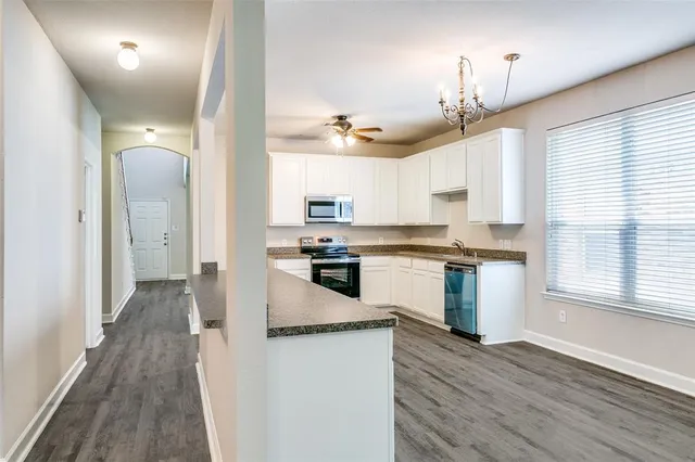a kitchen with a refrigerator cabinets and wooden floor