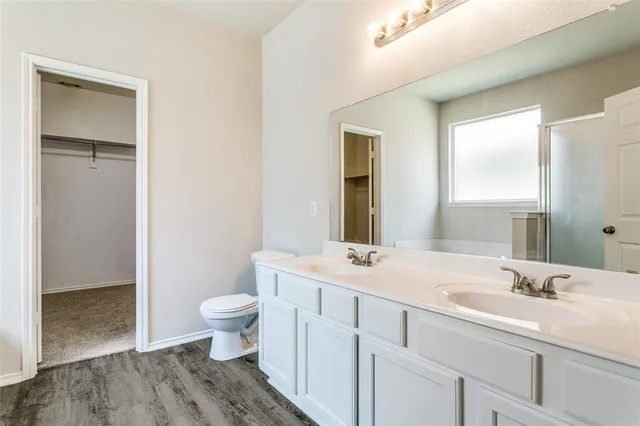 a bathroom with a sink a toilet and a large mirror