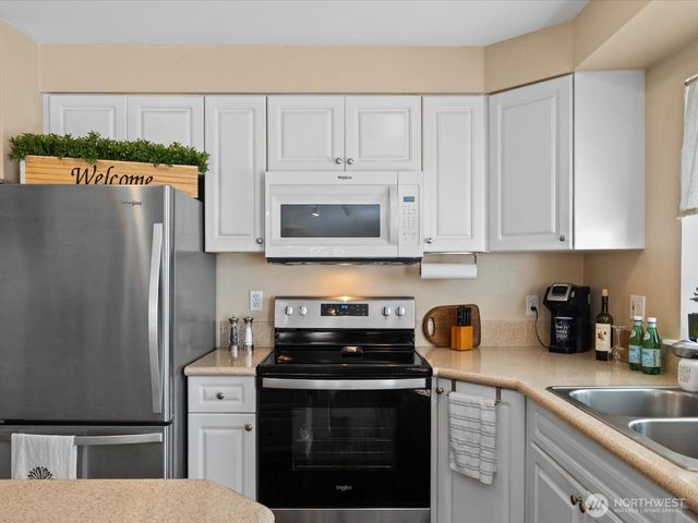 a kitchen with stainless steel appliances granite countertop a refrigerator stove and sink