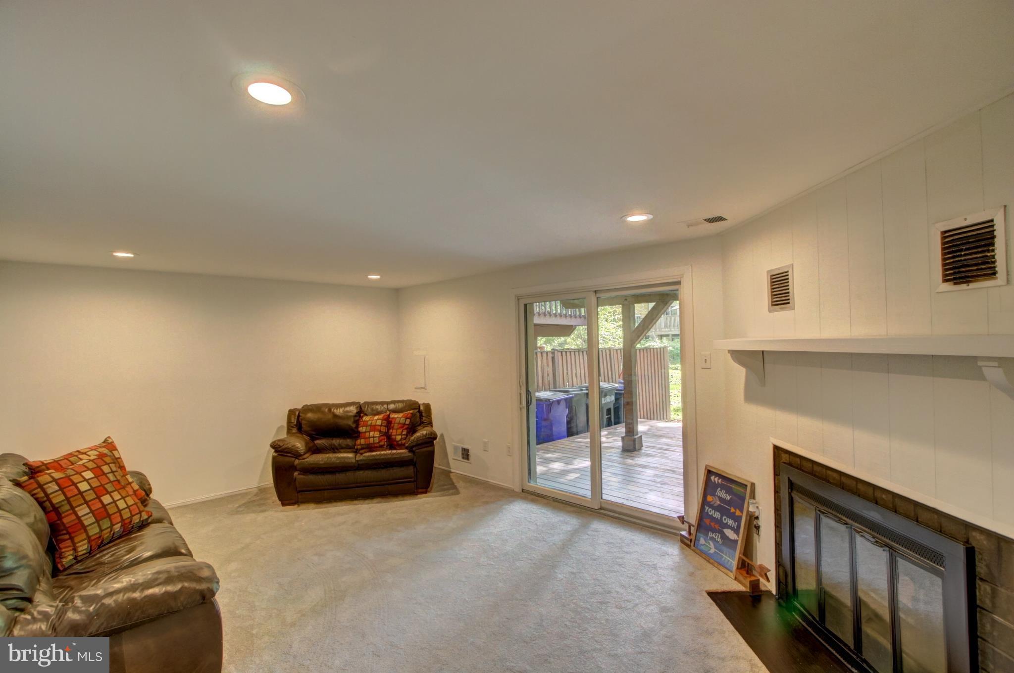7068 Winter Rose Path Columbia, MD 21045 - Photo 22 of 30 a living room with furniture a fireplace and a flat screen tv