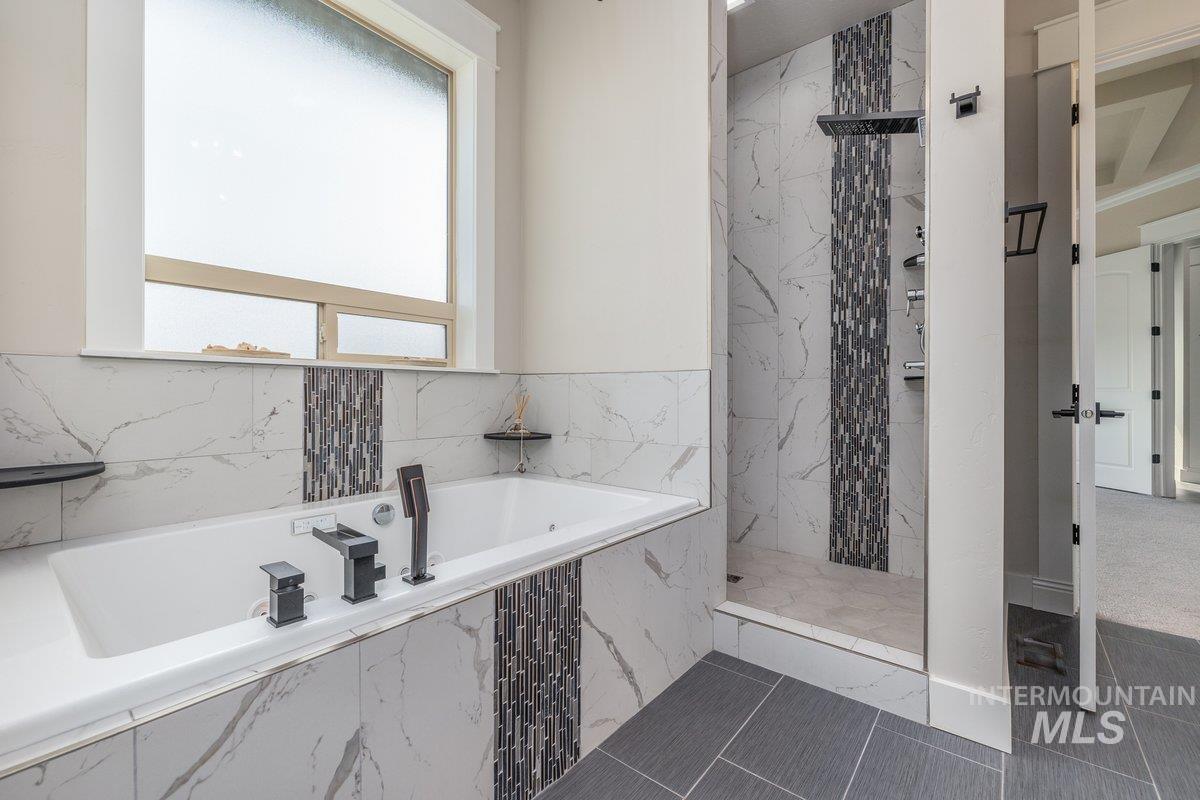 5990 West View Drive Meridian, ID 83642 - Photo 20 of 50 Full bathroom featuring a garden tub, a marble finish shower, and dark tile patterned floors