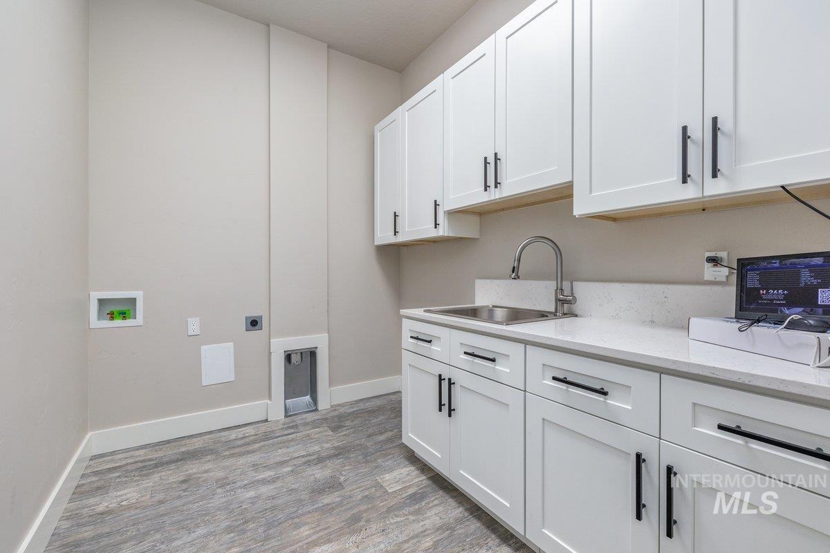 5990 West View Drive Meridian, ID 83642 - Photo 24 of 50 Laundry area with electric dryer hookup, light wood-style floors, hookup for a washing machine, and cabinet space