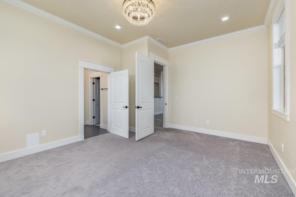 5990 West View Drive Meridian, ID 83642 - Photo 29 of 50 Unfurnished bedroom featuring ornamental molding, carpet flooring, and a chandelier