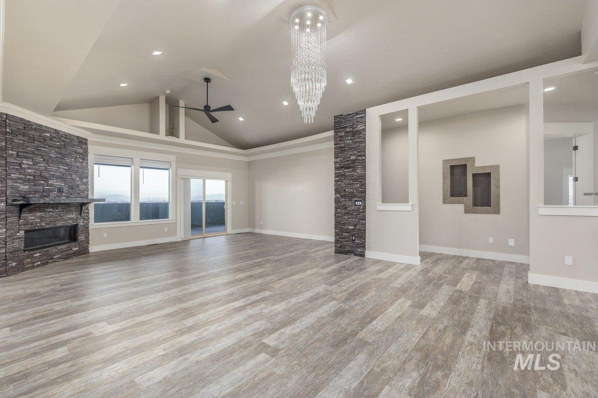 5990 West View Drive Meridian, ID 83642 - Photo 10 of 50 Unfurnished living room featuring a fireplace, ceiling fan, light wood-style flooring, and high vaulted ceiling