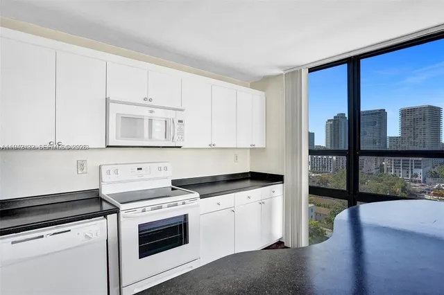 a kitchen with granite countertop a stove sink and cabinets