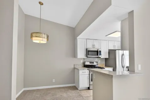 a kitchen with stainless steel appliances granite countertop a refrigerator and a stove top oven