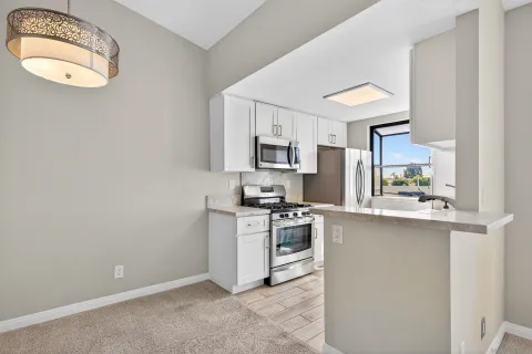 a kitchen with stainless steel appliances granite countertop a stove a sink and a refrigerator