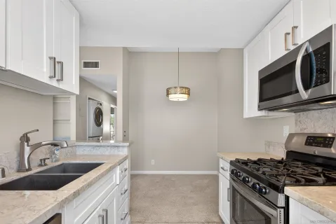 a kitchen with stainless steel appliances granite countertop a sink stove and microwave