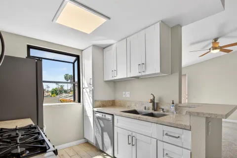 a kitchen with stainless steel appliances granite countertop a sink and a refrigerator