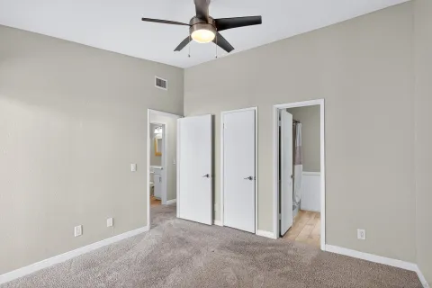 an empty room with chandelier fan