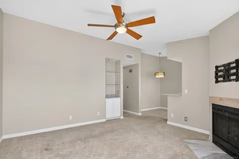 an empty room with closet and a ceiling fan