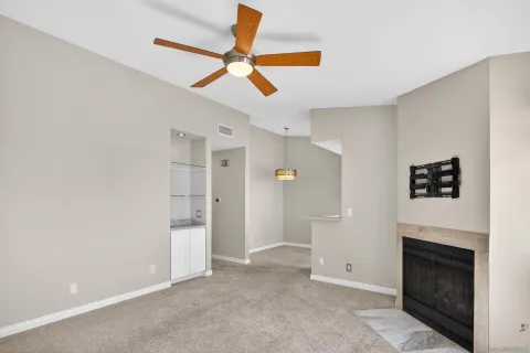 an empty room with windows and fireplace