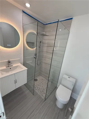 a bathroom with a sink a toilet and shower