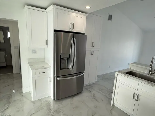 a kitchen with a refrigerator and cabinets