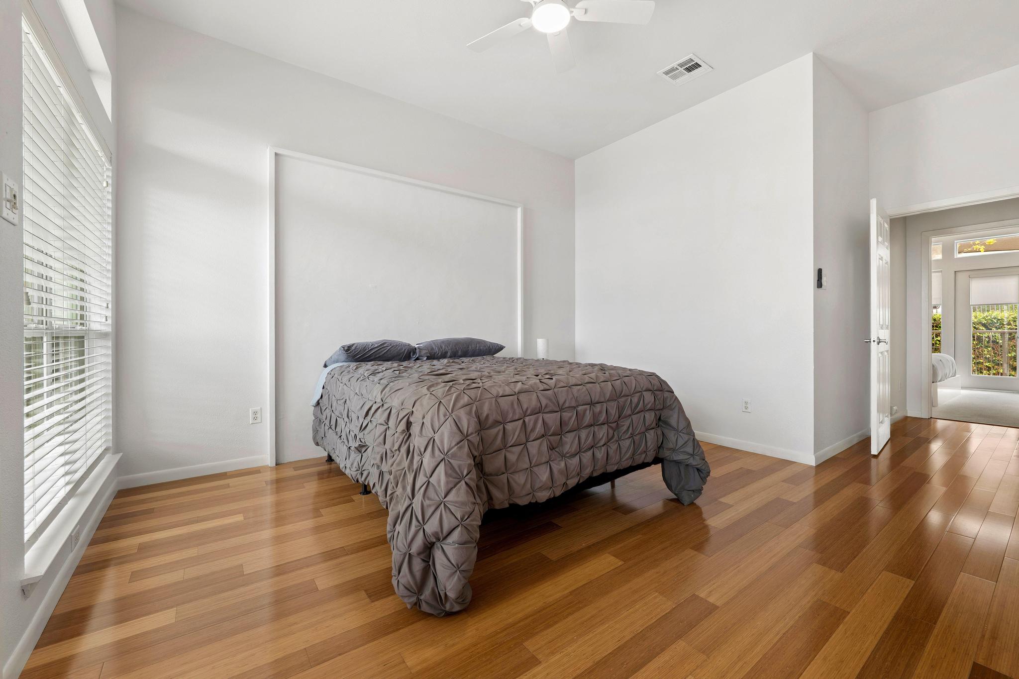 2918 Ranch Road 620, Unit J162 Austin, TX 78734 - Photo 20 of 26 Bright bedroom with wood-finish flooring, white walls, and a ceiling fan