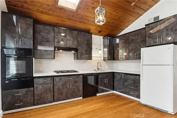 a kitchen with stainless steel appliances granite countertop a sink a stove and refrigerator
