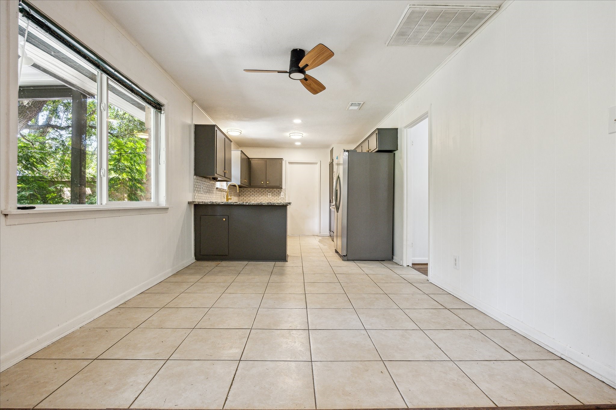 5419 Beechnut Street Houston, TX 77096 - Photo 9 of 28 Light-filled breakfast area with tile flooring, large window overlooking the backyard, and open access to the kitchen.