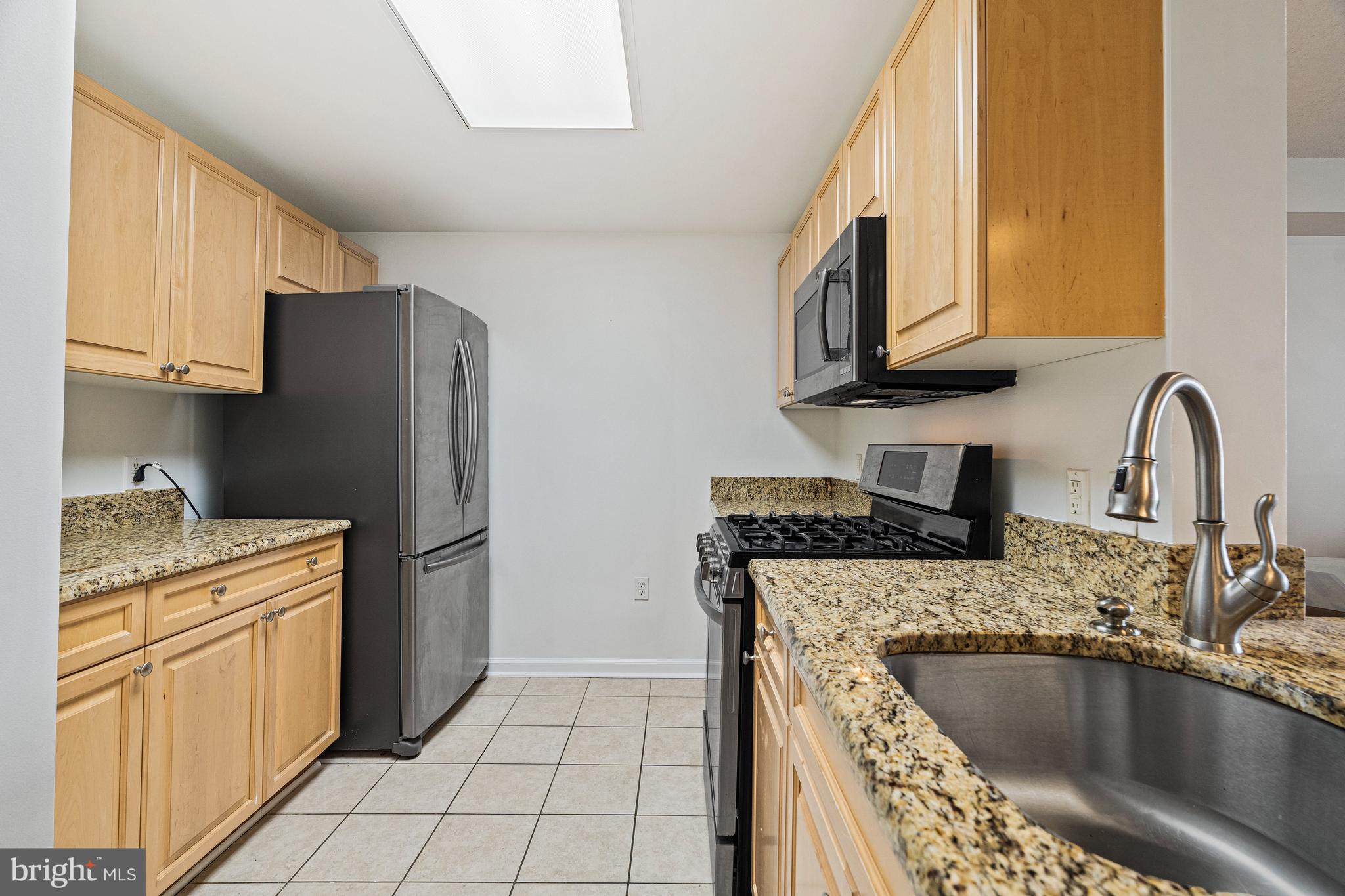 2726 Gallows Road, Unit 712 Vienna, VA 22180 - Photo 4 of 55 a kitchen with granite countertop a sink a stove and refrigerator