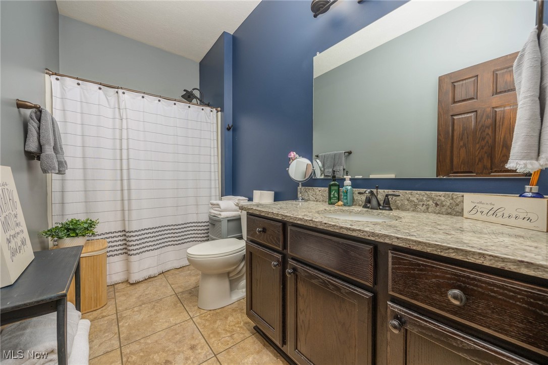 2851 Barnett Ridge Road Fleming, OH 45729 - Photo 30 of 40 Bathroom with tile patterned flooring, toilet, vanity, and a shower with shower curtain