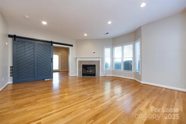 a view of empty room with wooden floor and fireplace