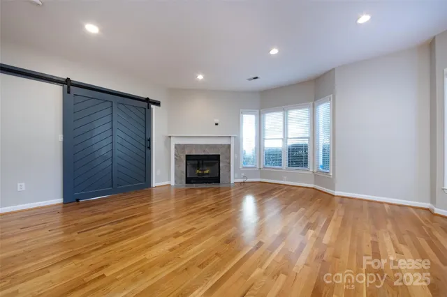 a view of empty room with wooden floor and fireplace