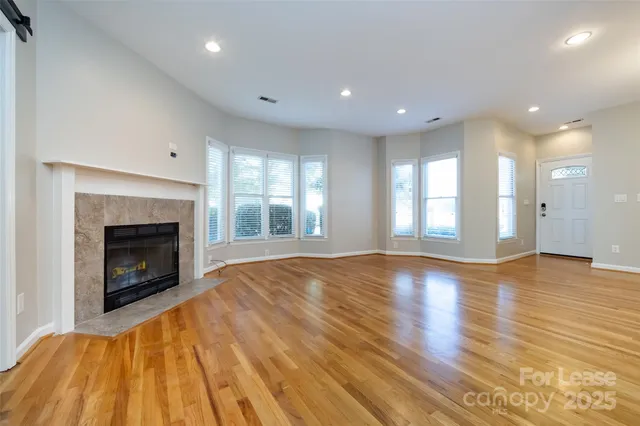 a view of empty room with wooden floor and fireplace