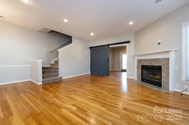 a view of empty room with wooden floor and fireplace