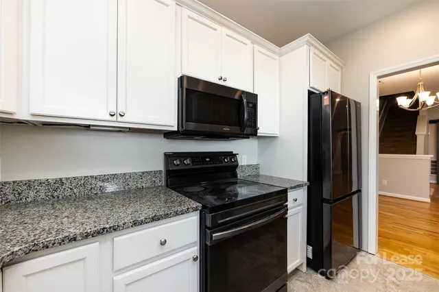 a kitchen with stainless steel appliances granite countertop a refrigerator stove and microwave