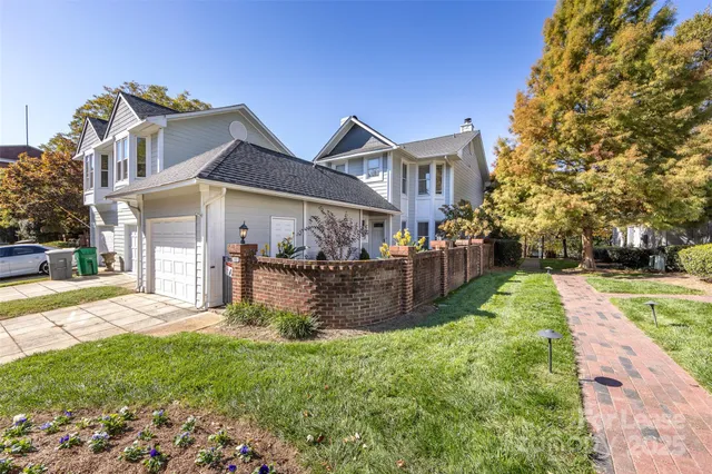 a view of a big house with a big yard and large tree