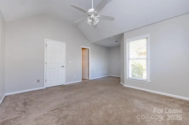 an empty room with windows and ceiling fan