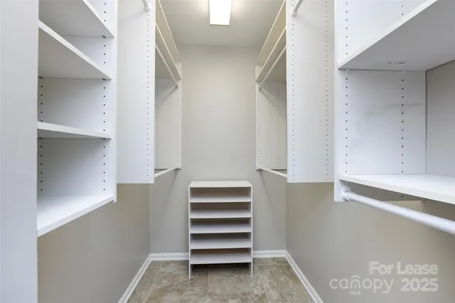 a view of walk in closet with empty racks