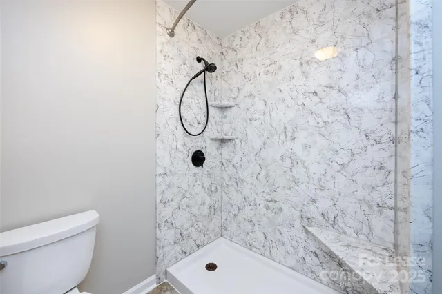 a bathroom with a toilet and a shower