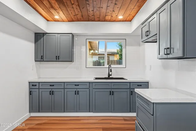 a kitchen with a sink cabinets and wooden floor
