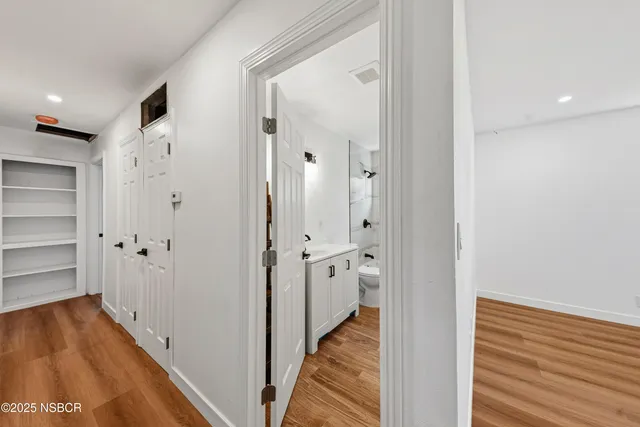 a view of a hallway with wooden floor and staircase