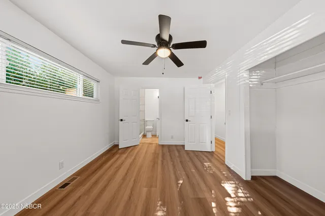 a view of empty room with wooden floor