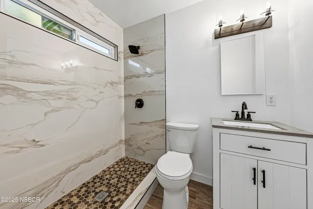 a bathroom with a sink a toilet and shower