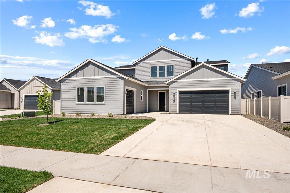 View of front of property featuring board and batten siding, driveway, and an attached garage
