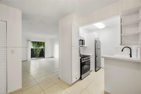 a view of a kitchen with a sink refrigerator and window