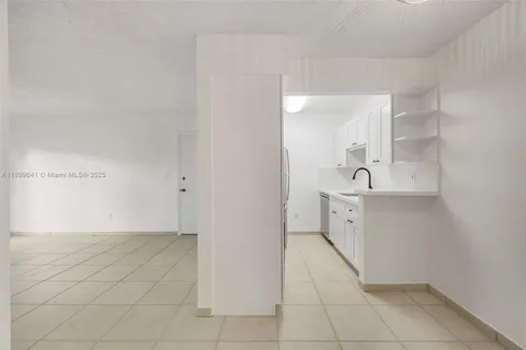 a view of a kitchen with white cabinets