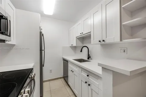 a kitchen with white cabinets and a stove top oven