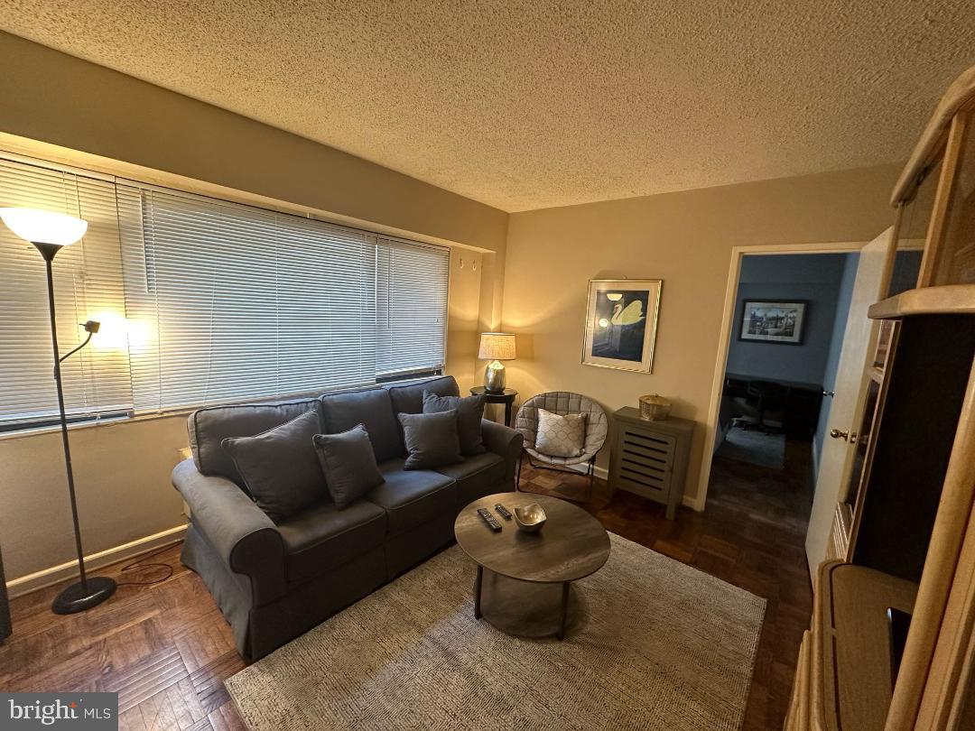 2141 I Street Northwest, Unit 615 Washington, DC 20037 - Photo 1 of 16 a living room with furniture and a flat screen tv