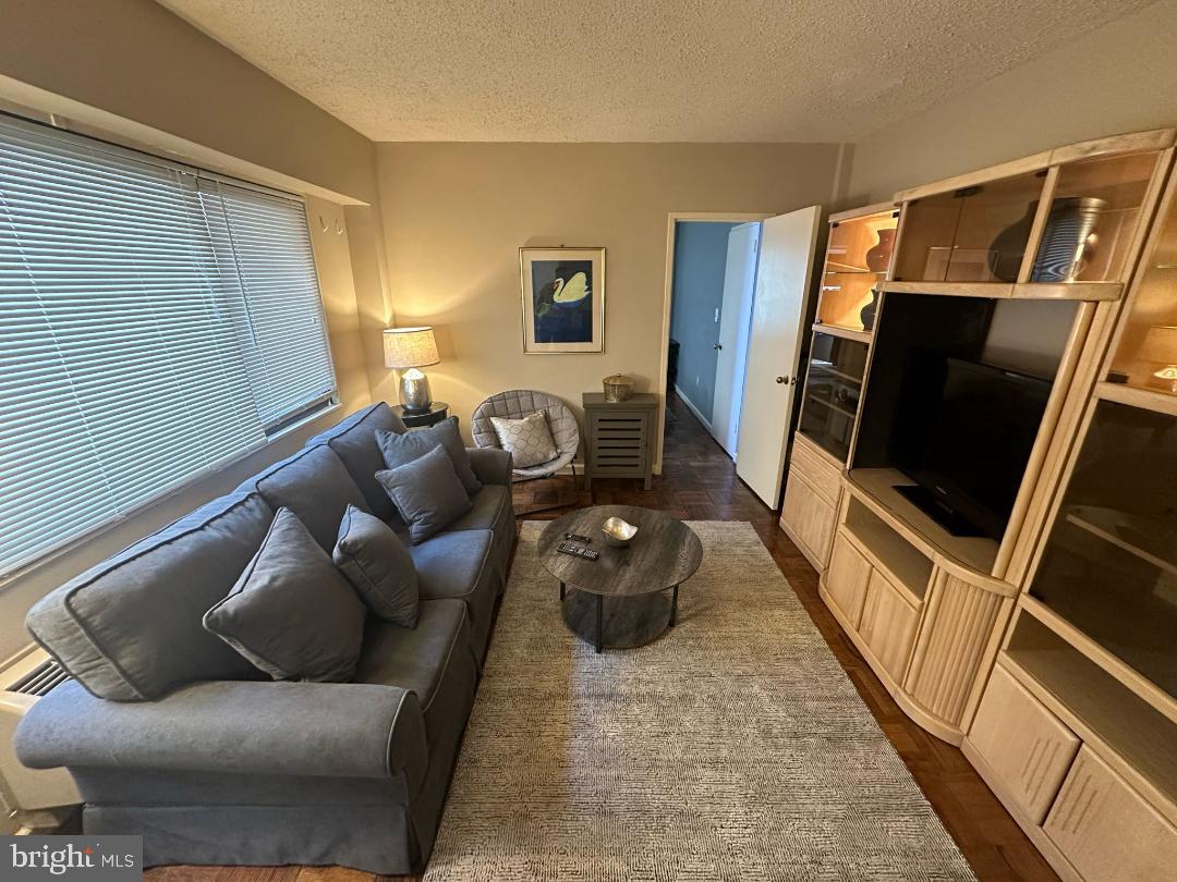 2141 I Street Northwest, Unit 615 Washington, DC 20037 - Photo 4 of 16 a living room with furniture and a flat screen tv
