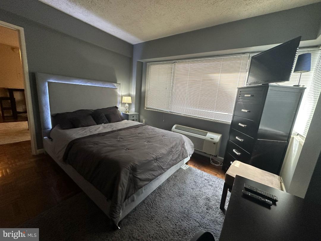 2141 I Street Northwest, Unit 615 Washington, DC 20037 - Photo 6 of 16 a bedroom with a bed and wooden floor